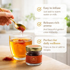 a glass of redish water and spoon pouring saffron in it after that the color of water become redish and some quality sowing , easy to infuse, release rich aroma , perfect for daily wellness and jar f portho saffron 
